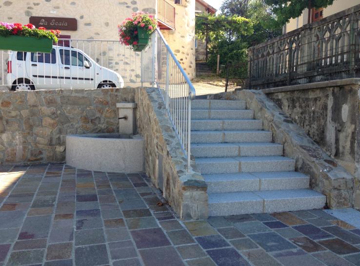 petit escalier à proximité d'une fontaine qui mène a une maison